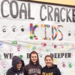 Photo of Coal Cracker Kids cleaning up teh facade of their new headquarters.