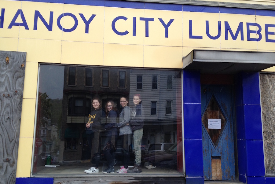 Photo of Coal Cracker Kids participants after removing a tarp from the front window of their new headquarters.