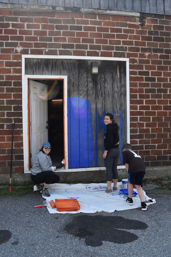 Photo of the Rhoades family painting on Railroad Street.